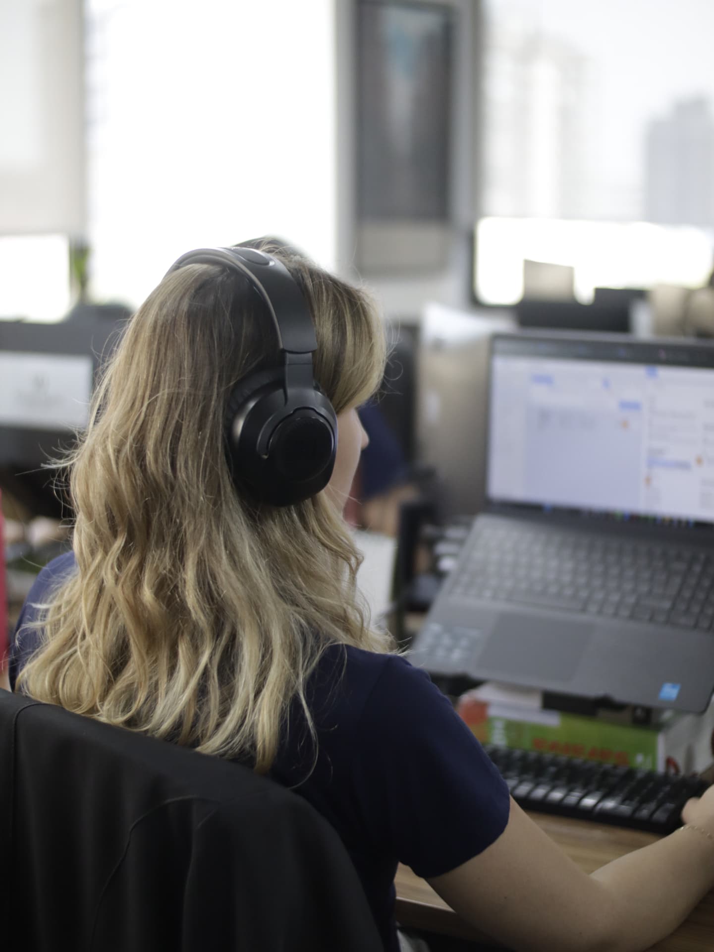 Profissional do escritório em atendimento com headset e notebook